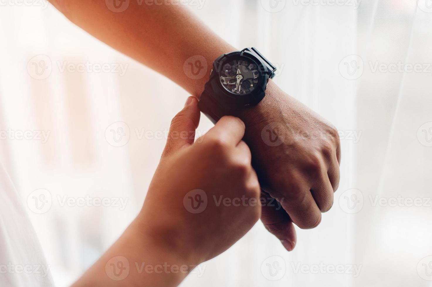 Hands and black watches of young men who like time concept watches photo