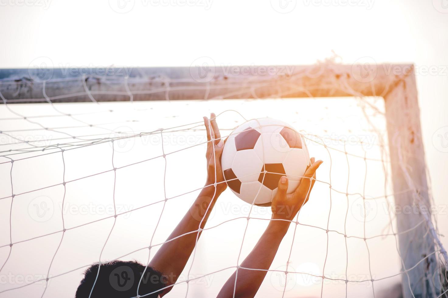 la imagen recortada de deportistas que atrapan la pelota y el campo de fútbol. concepto de imagen deportiva. foto