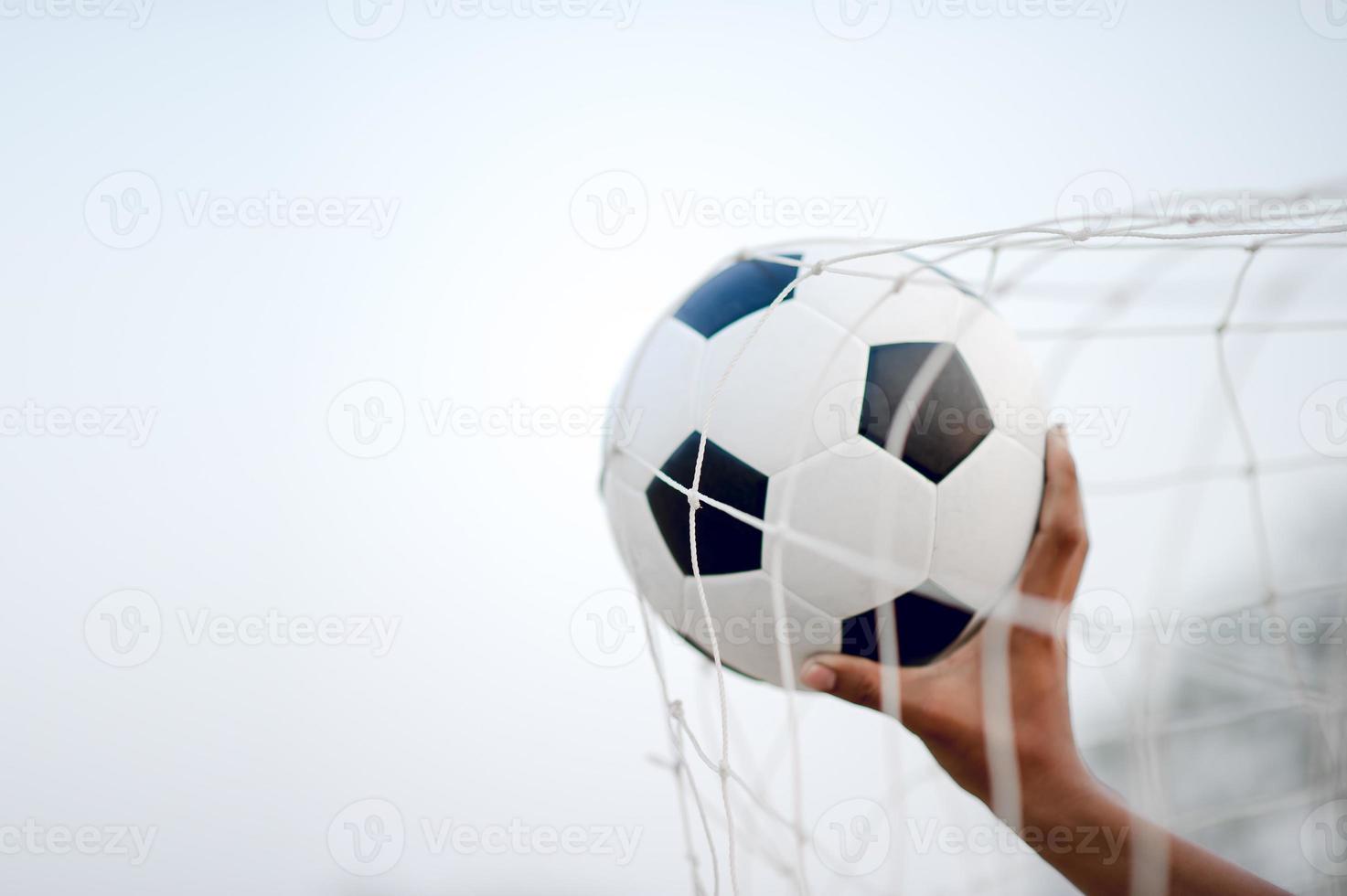 la imagen recortada de deportistas que atrapan la pelota y el campo de fútbol. concepto de imagen deportiva. foto