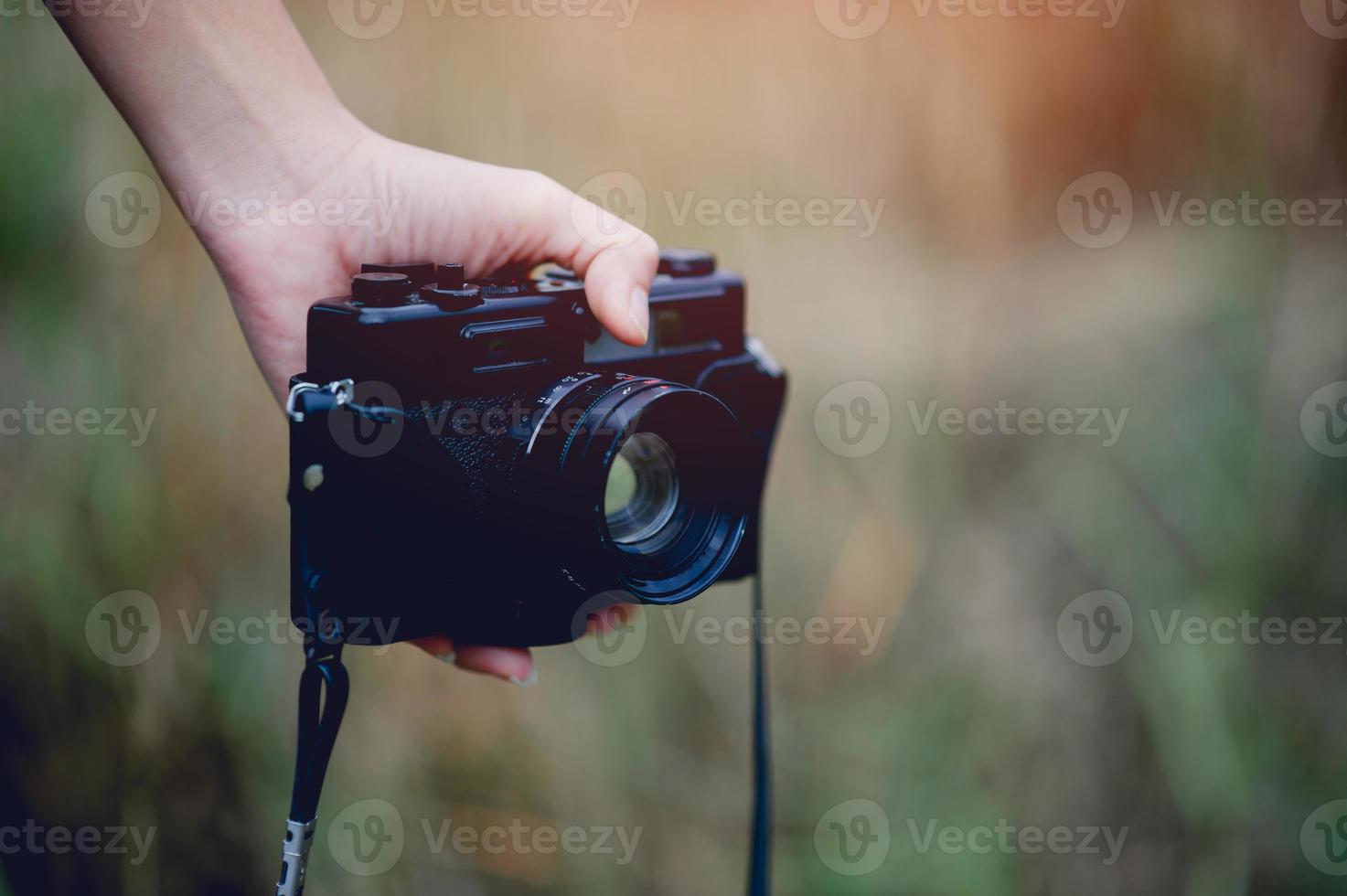 mano y cámara del fotógrafo sosteniendo y llevando la cámara para tomar fotografías foto