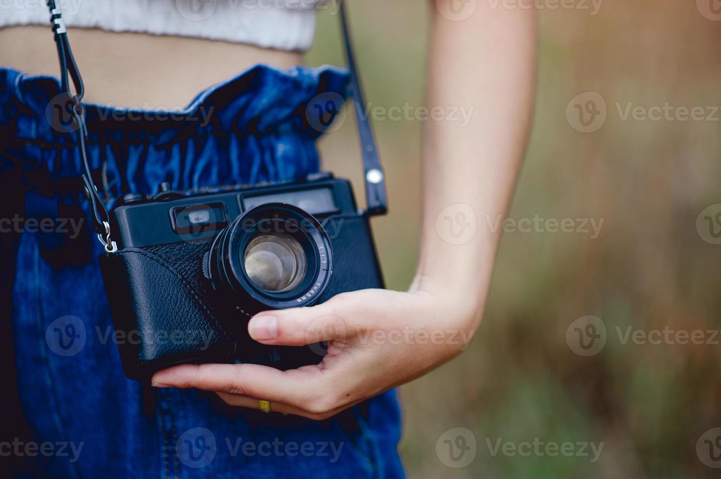 mano y cámara del fotógrafo sosteniendo y llevando la cámara para tomar fotografías foto