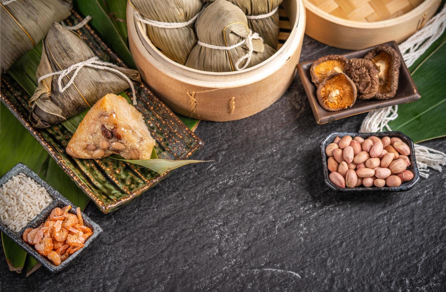 Close up, copy space, top view, famous asian chinese tasty handmade food in dragon boatduan wu festival, steamed rice dumplings shaped pyramidal by leaves ingredients photo