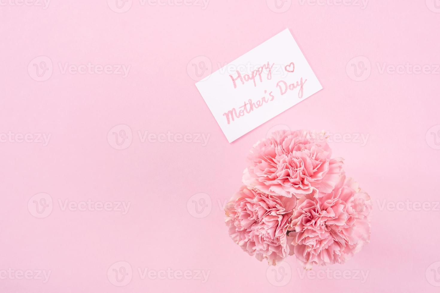 Top view, flat lay, mock up, copy space, handwritten greeting card template isolated with pale pink background, idea concept of thanks, wishes, craft carnations bouquet photo