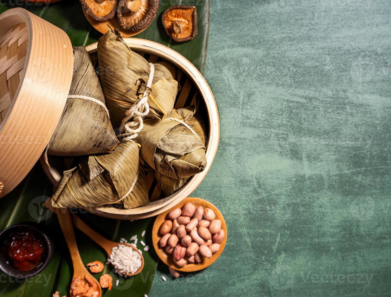 primer plano, espacio de copia, vista superior, plano. famosa comida asiática china sabrosa hecha a mano en el festival duan wu, albóndigas de arroz al vapor con forma de ingredientes piramidales foto