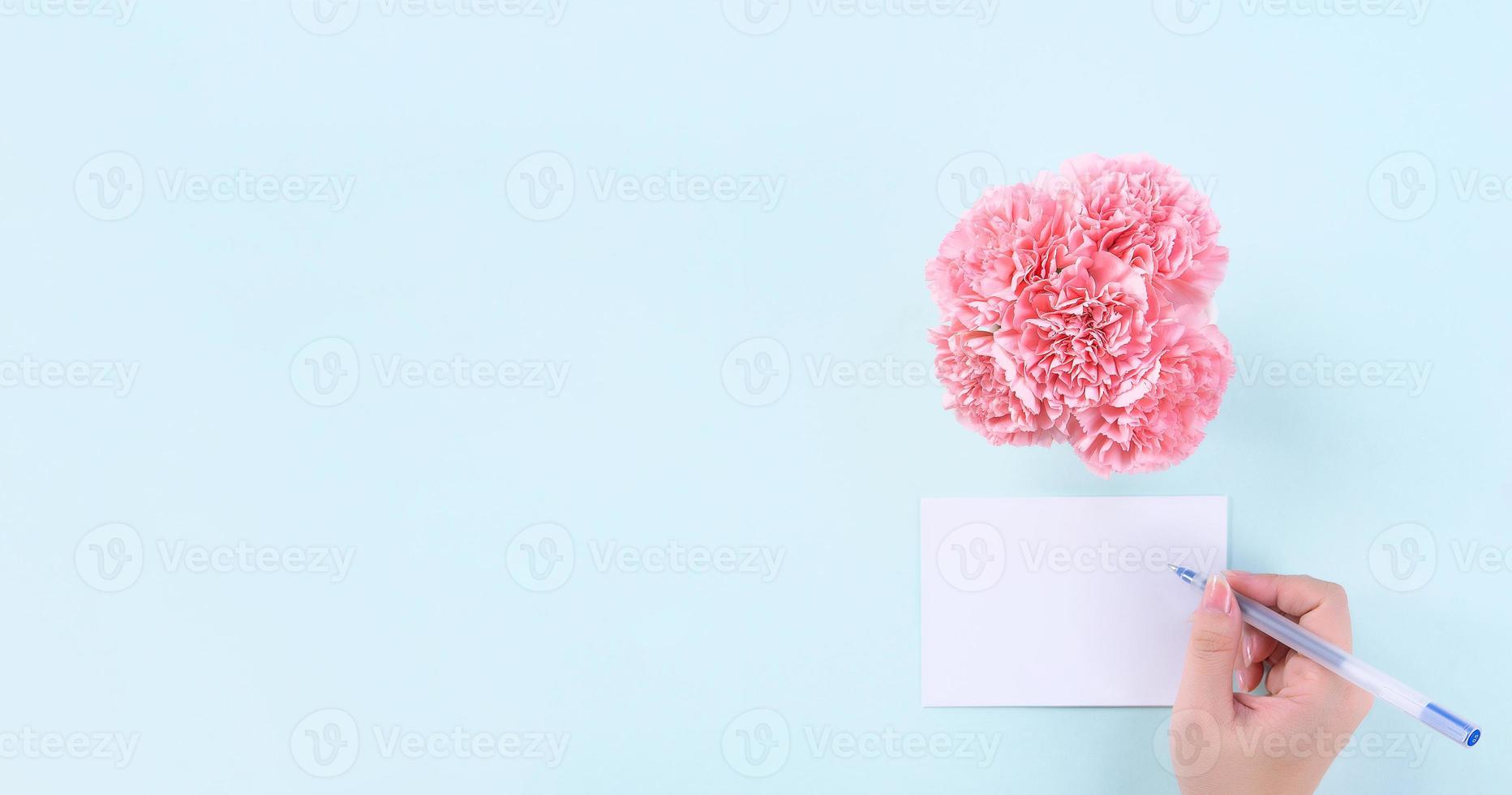 Handwritten greeting card by young teenage person isolated with pale blue background, idea concept of thanks, wishes, craft carnations bouquet, top view, copy space, flat lay, mock up photo
