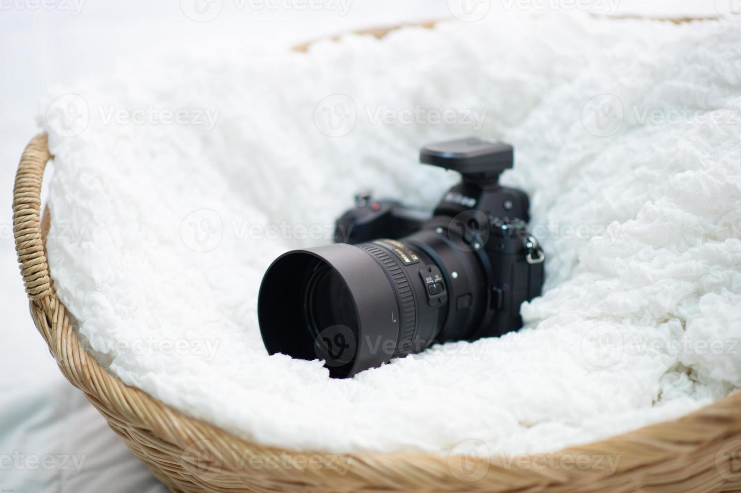 The black camera is well placed in a white cloth. photo