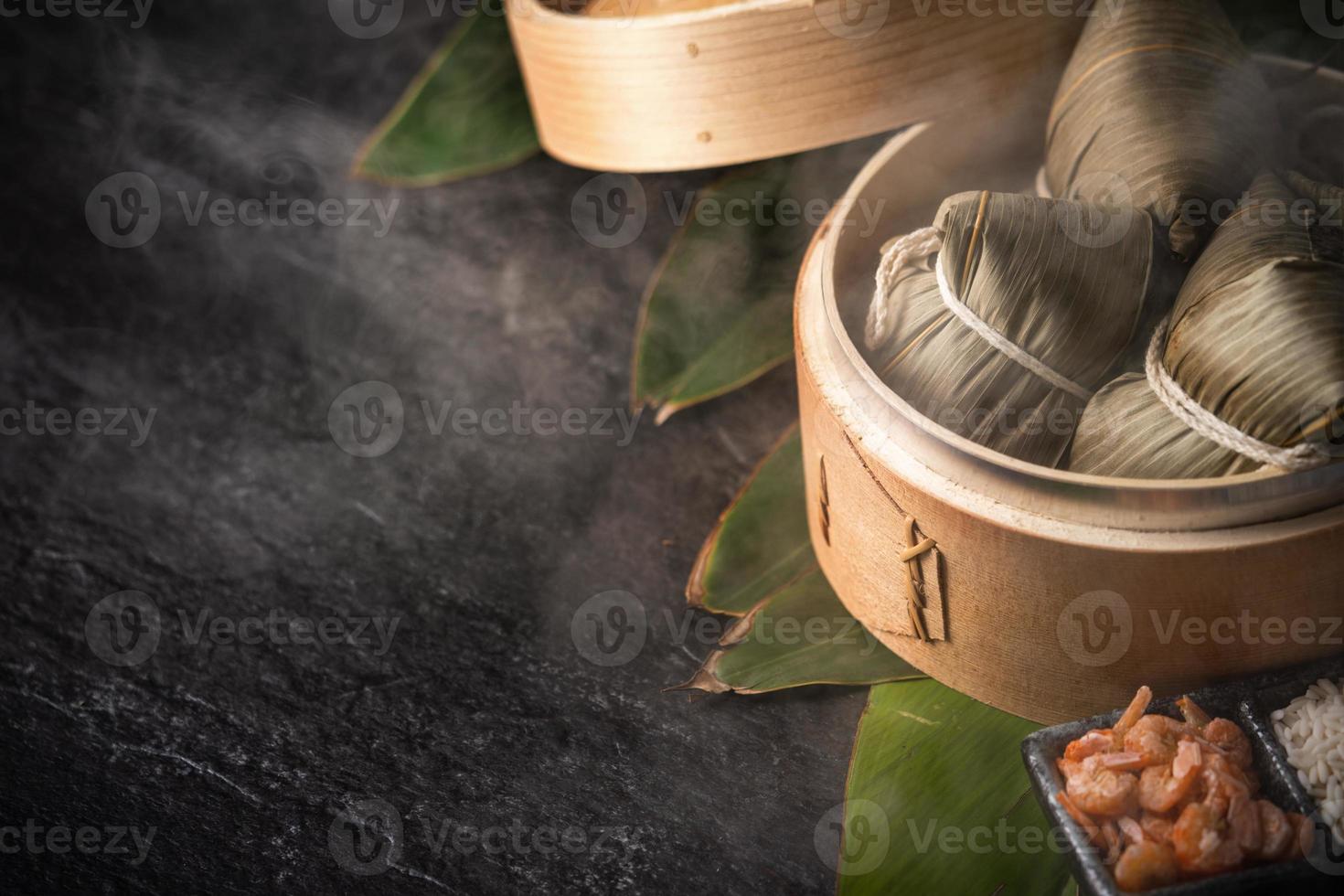 primer plano, espacio de copia, famosa comida asiática sabrosa hecha a mano en el festival dragon boat duan wu, fresco de albóndigas de arroz al vapor con forma piramidal envuelta por ingredientes de hojas foto