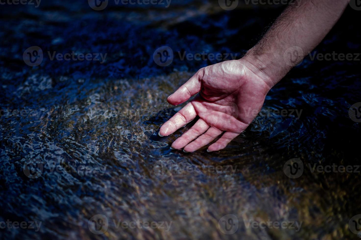 Hands and water flowing from natural waterfalls Water concept from natural waterfall photo