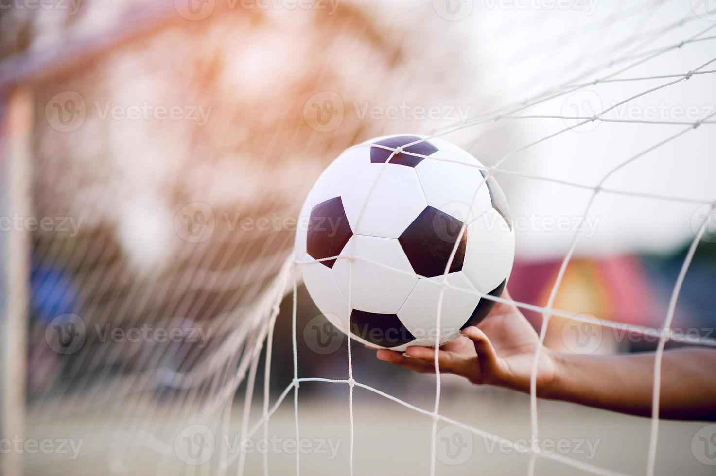 la imagen recortada de deportistas que atrapan la pelota y el campo de fútbol. concepto de imagen deportiva. foto