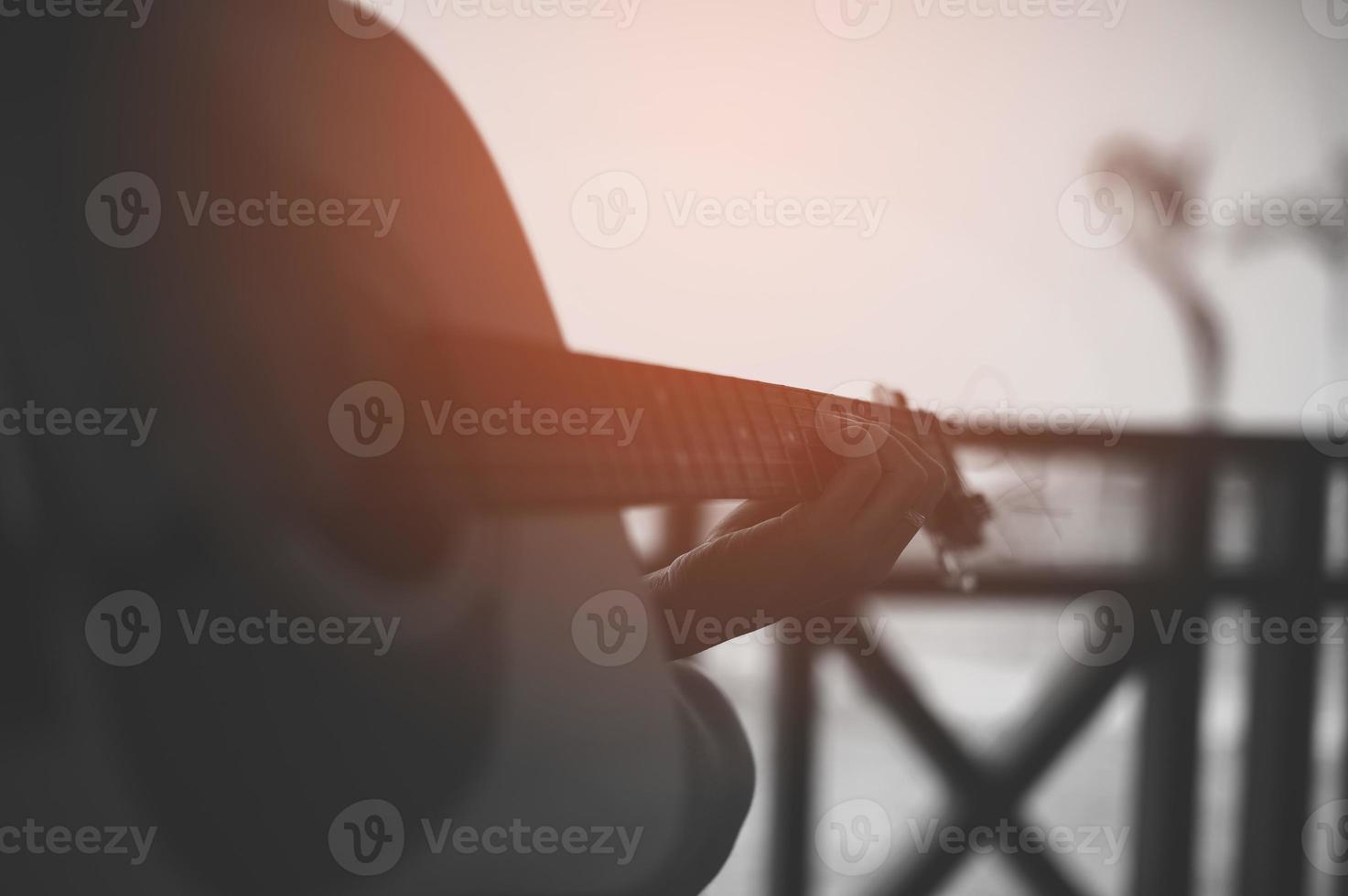 Hand and acoustic guitar of a professional guitarist photo