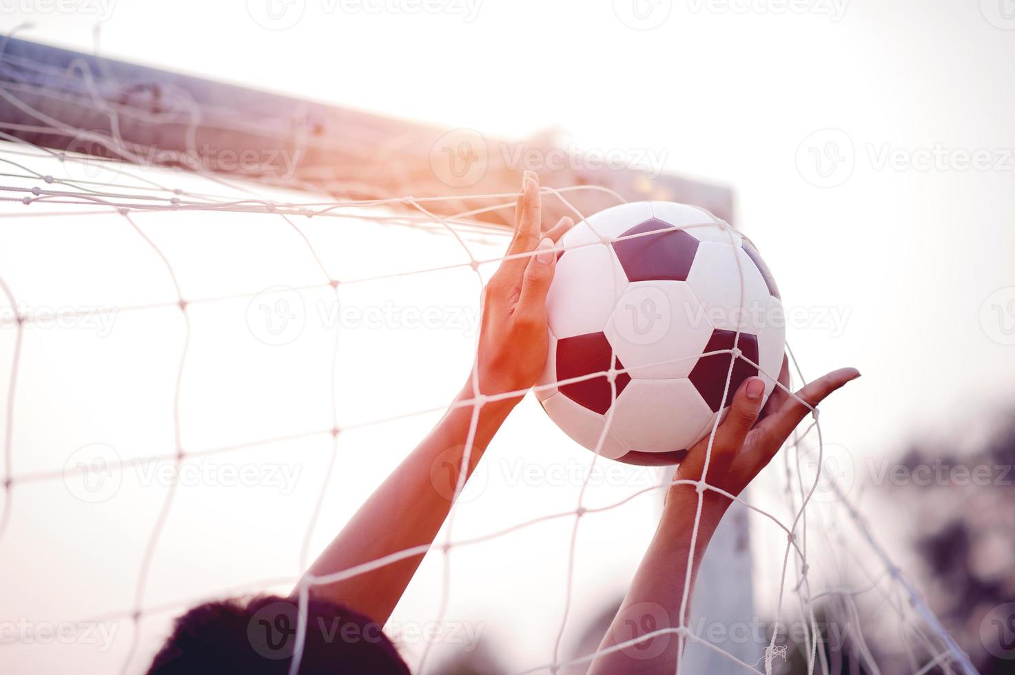 la imagen recortada de deportistas que atrapan la pelota y el campo de fútbol. concepto de imagen deportiva. foto