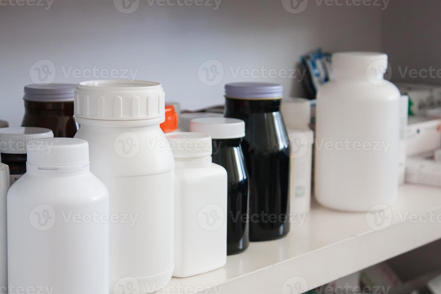 Bottles of pills arranged on shelf at drugstore photo