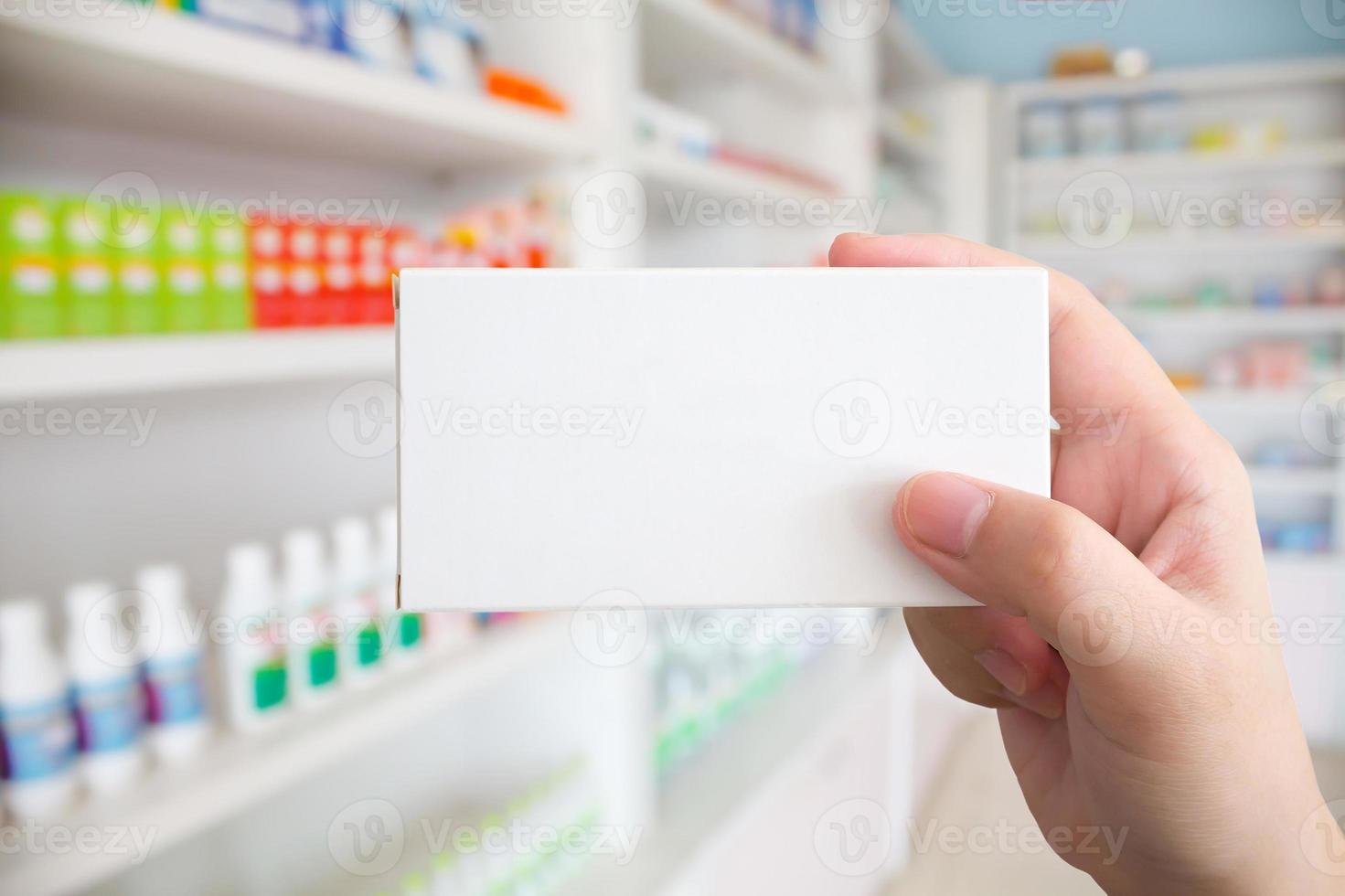 Close up pharmacist hand hold medicine box package photo