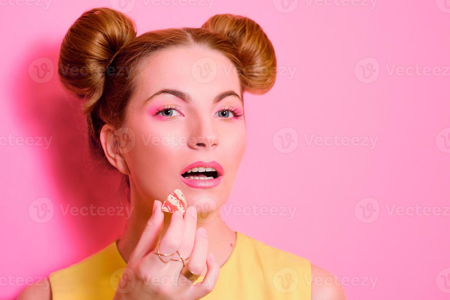 portrait of cute attractive blonde young woman with chocolate candy in her fingers photo