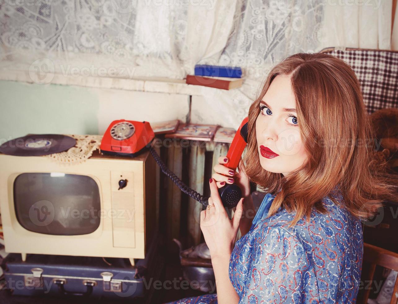 retrato de una mujer antigua al estilo de la urss hablando por teléfono antiguo en un interior retro foto