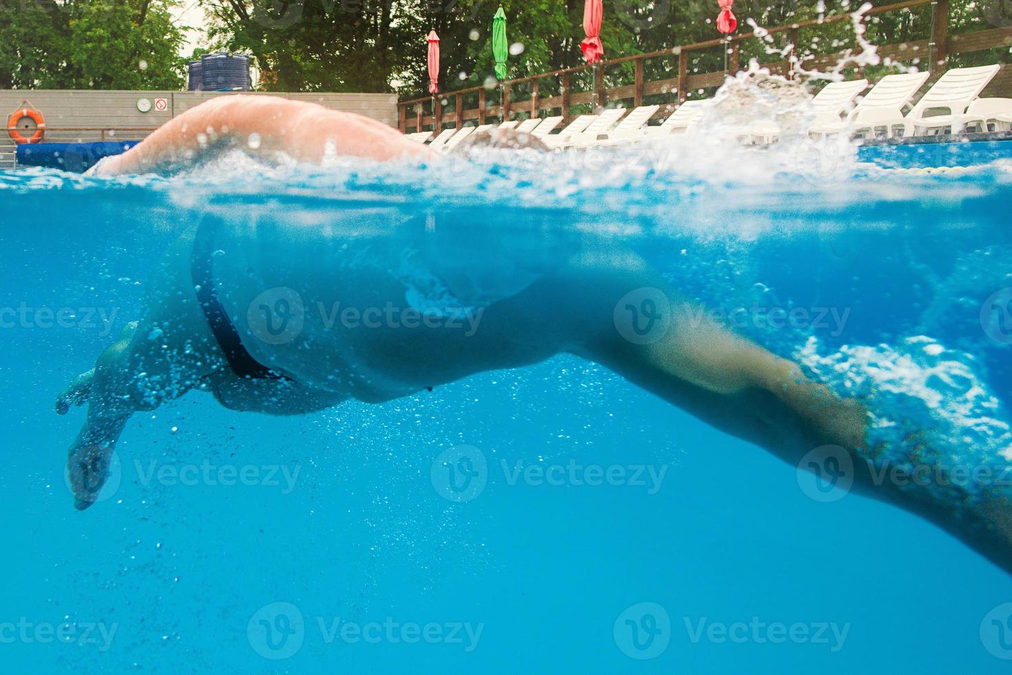 caucasian sportsman swimming in the swimming pool underwater photo