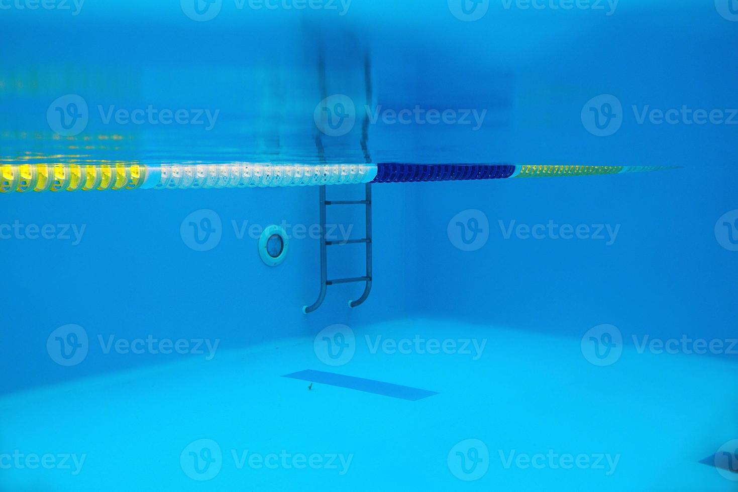 View of the swimming pool with metal ladder underwater photo