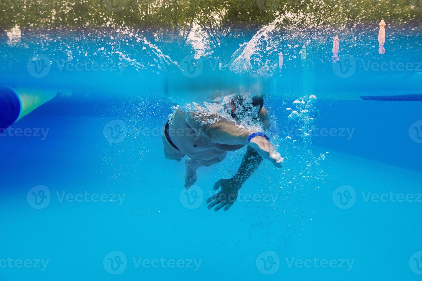 caucasian sportsman swimming in the swimming pool underwater photo