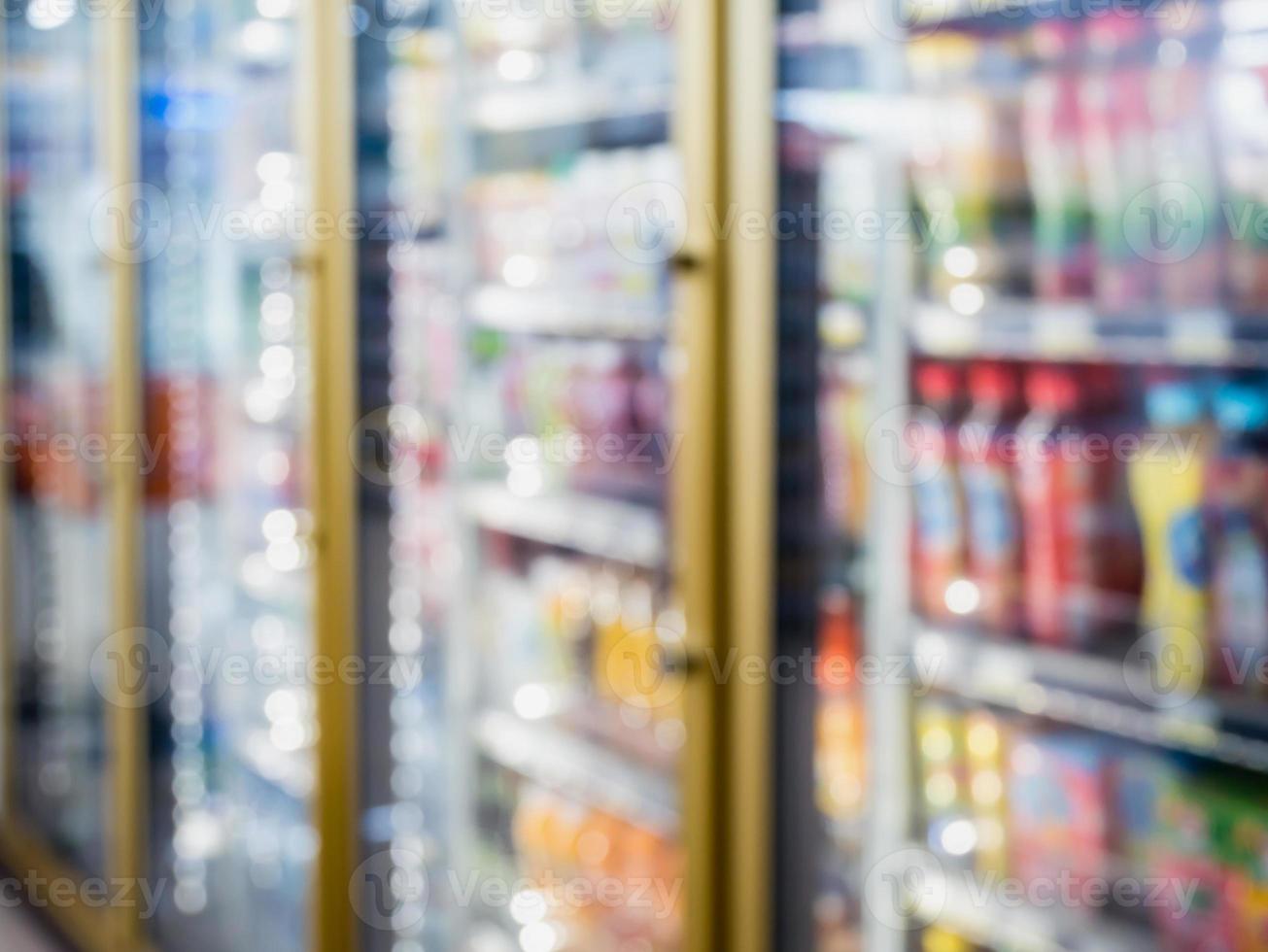 blur bottles of beverage on shelves in the freezer at supermarket photo