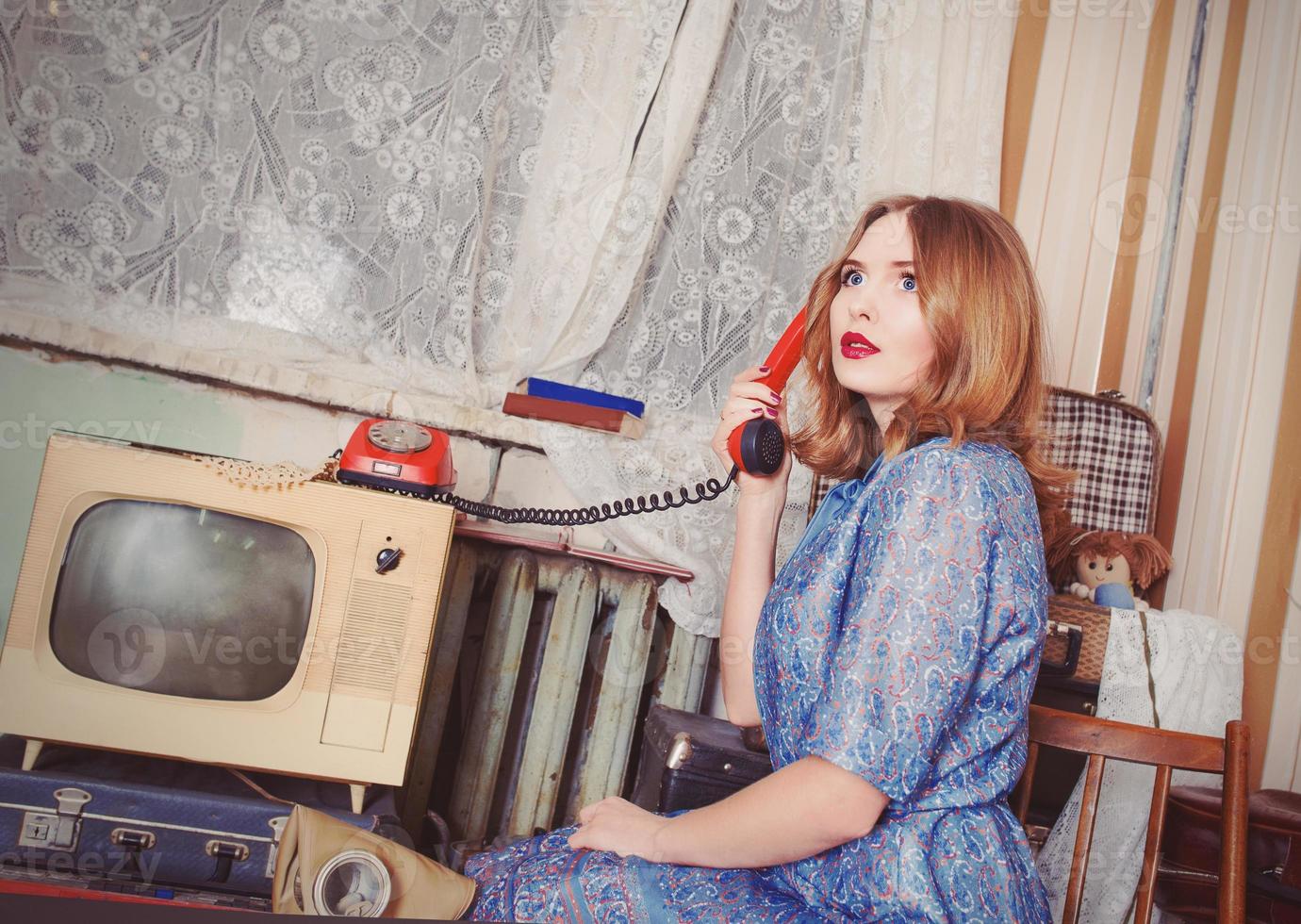retrato de una mujer antigua al estilo de la urss hablando por teléfono antiguo en un interior retro foto