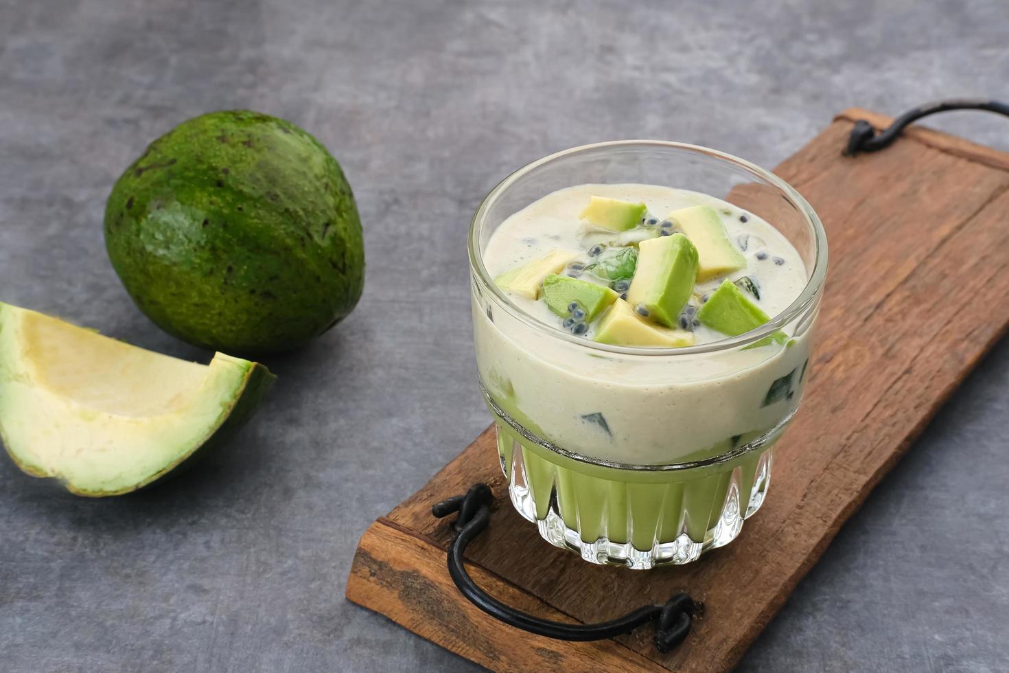 Avocado Milk Cheese Dessert is made from avocado, jelly, cheese, basil seeds, sweetened condensed milk and evaporated milk. Served in a glass. Space for text photo