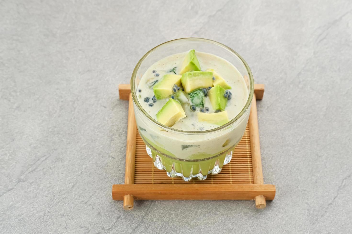 Avocado Milk Cheese Dessert is made from avocado, jelly, cheese, basil seeds, sweetened condensed milk and evaporated milk. Served in a glass. Space for text photo