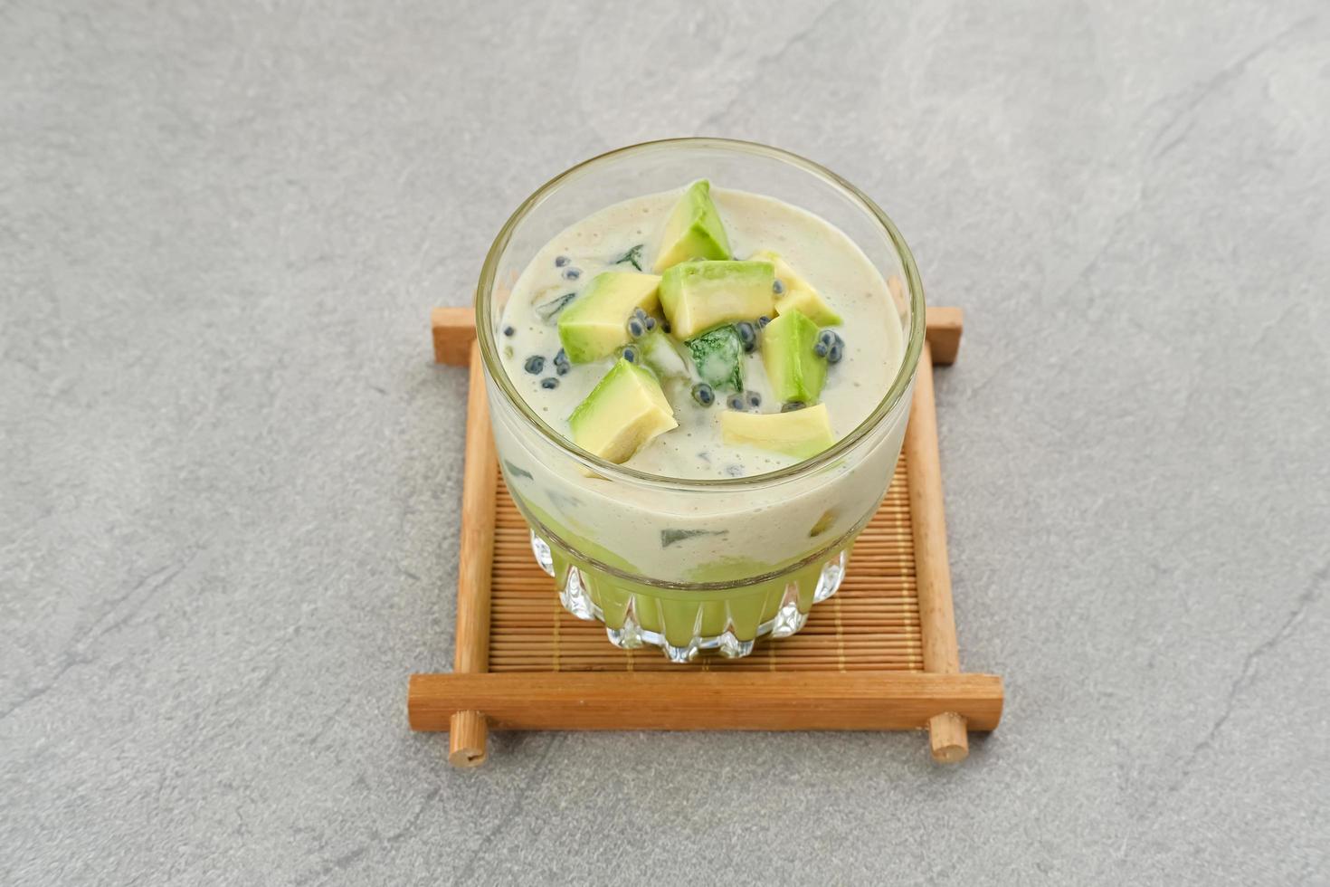 Avocado Milk Cheese Dessert is made from avocado, jelly, cheese, basil seeds, sweetened condensed milk and evaporated milk. Served in a glass. Space for text photo