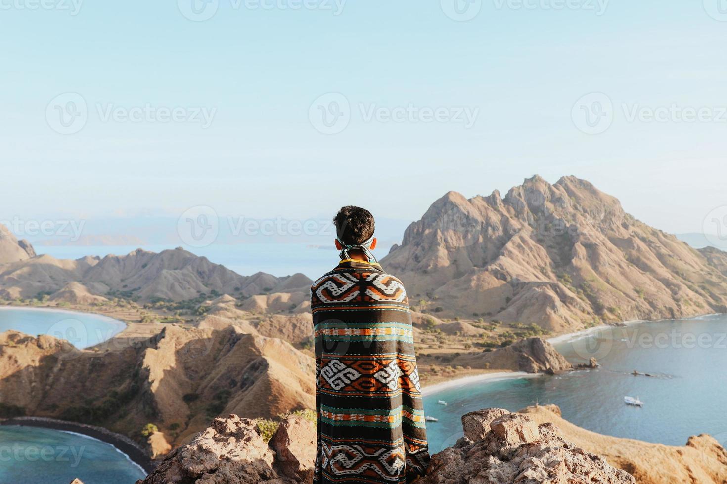 Asian male tourists wearing Indonesian traditional cloth called songket cloth enjoying the beautiful scenery on Padar Island photo