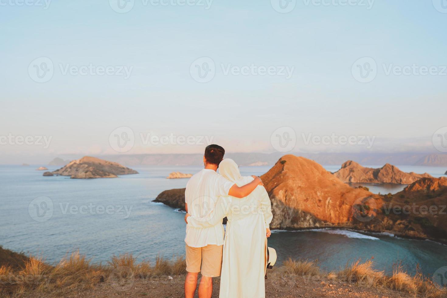 Romantic couple enjoying sea view from top hill on summer day photo