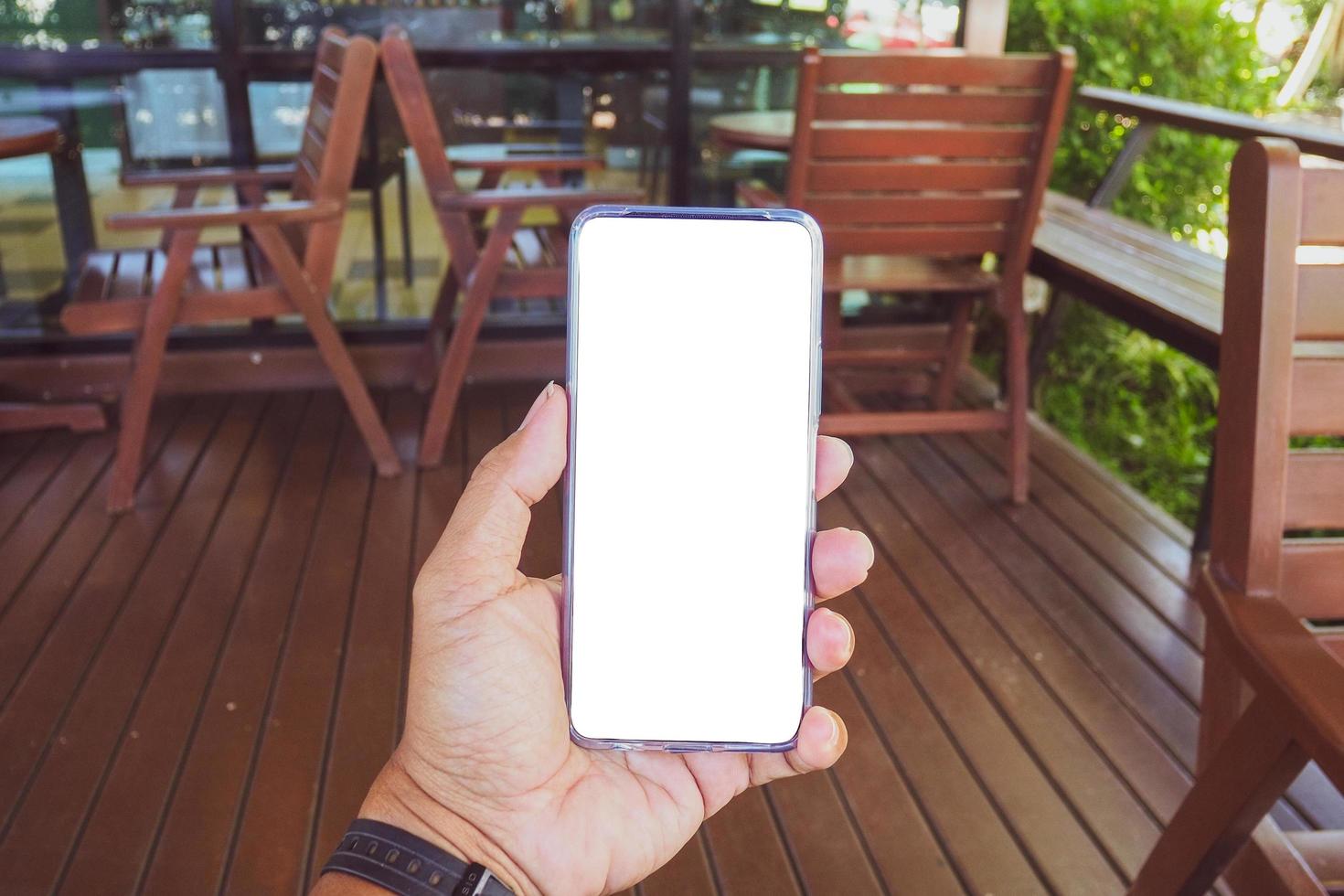 Close-up of male hand holding smartphone with mockup. .Man holding phone on white background with copy space. Man holding smartphone with white screen. Hands with blank cell phone display, Close-up. photo