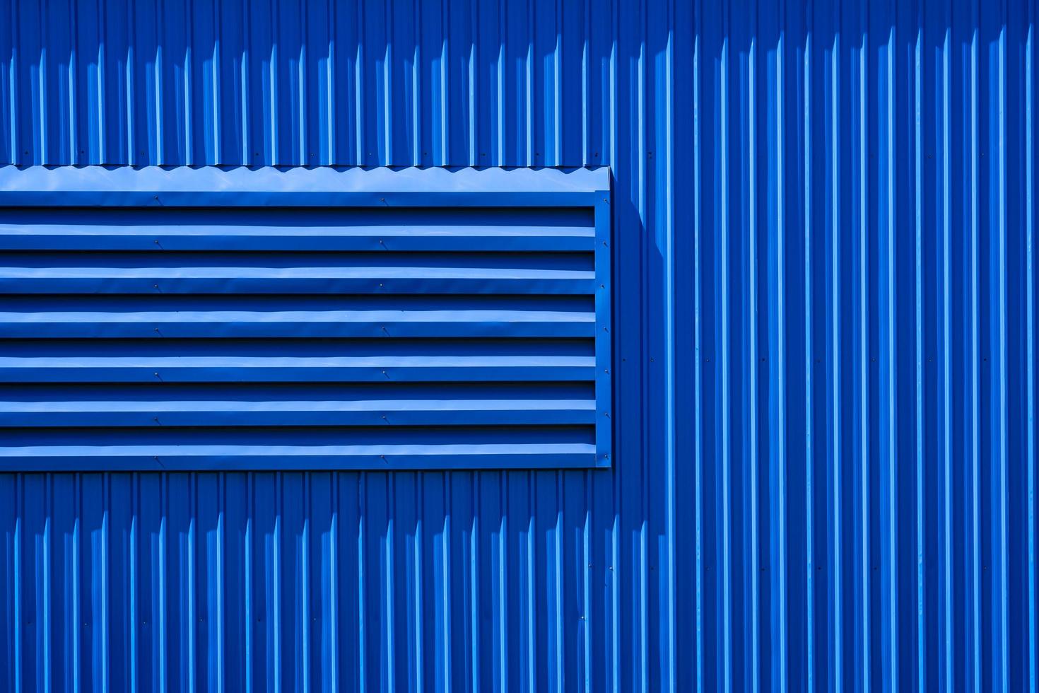 Sunlight on aluminum louver surface of blue warehouse building wall photo