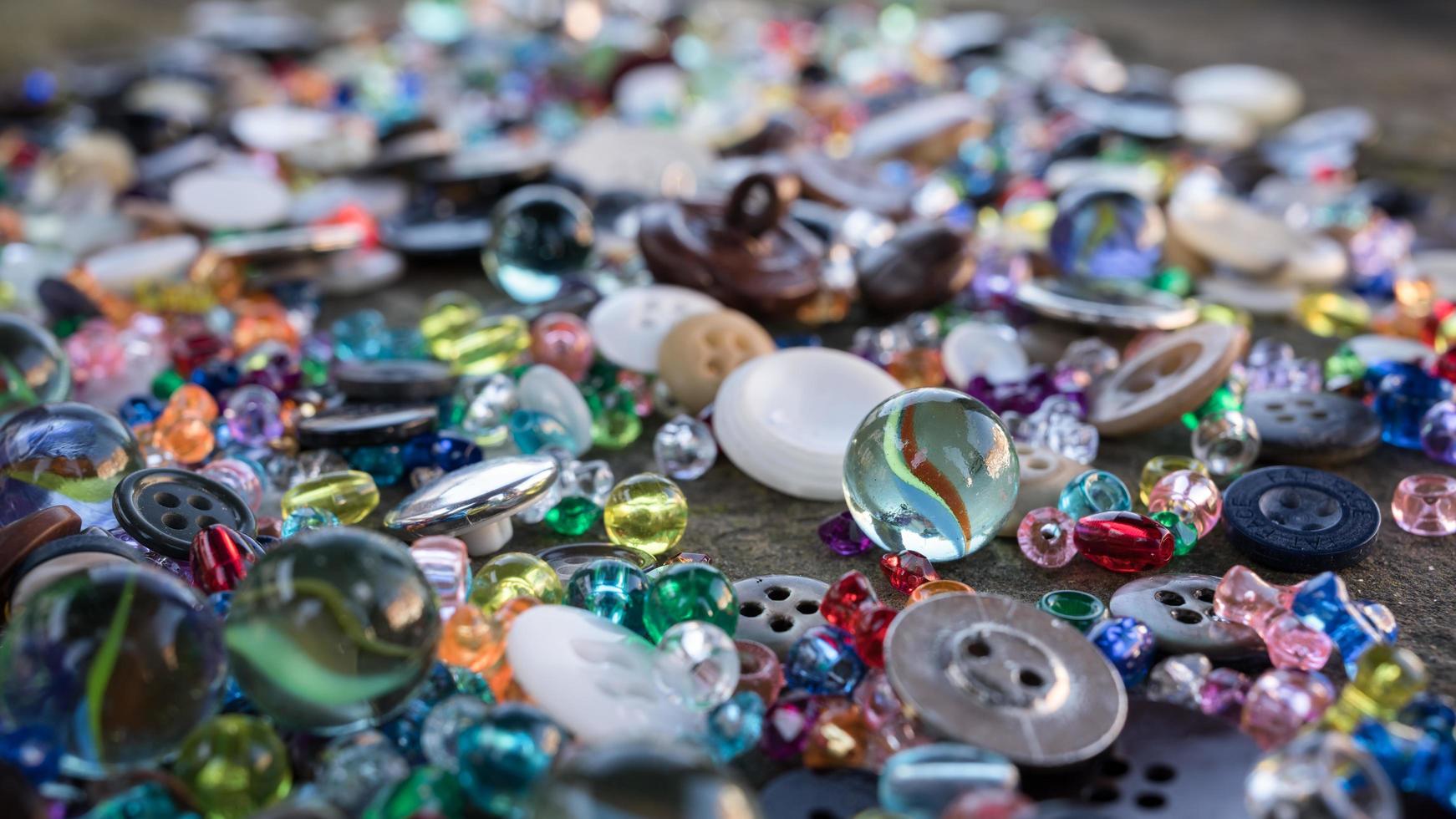 A group of randomly scattered beads, buttons and marbles photo