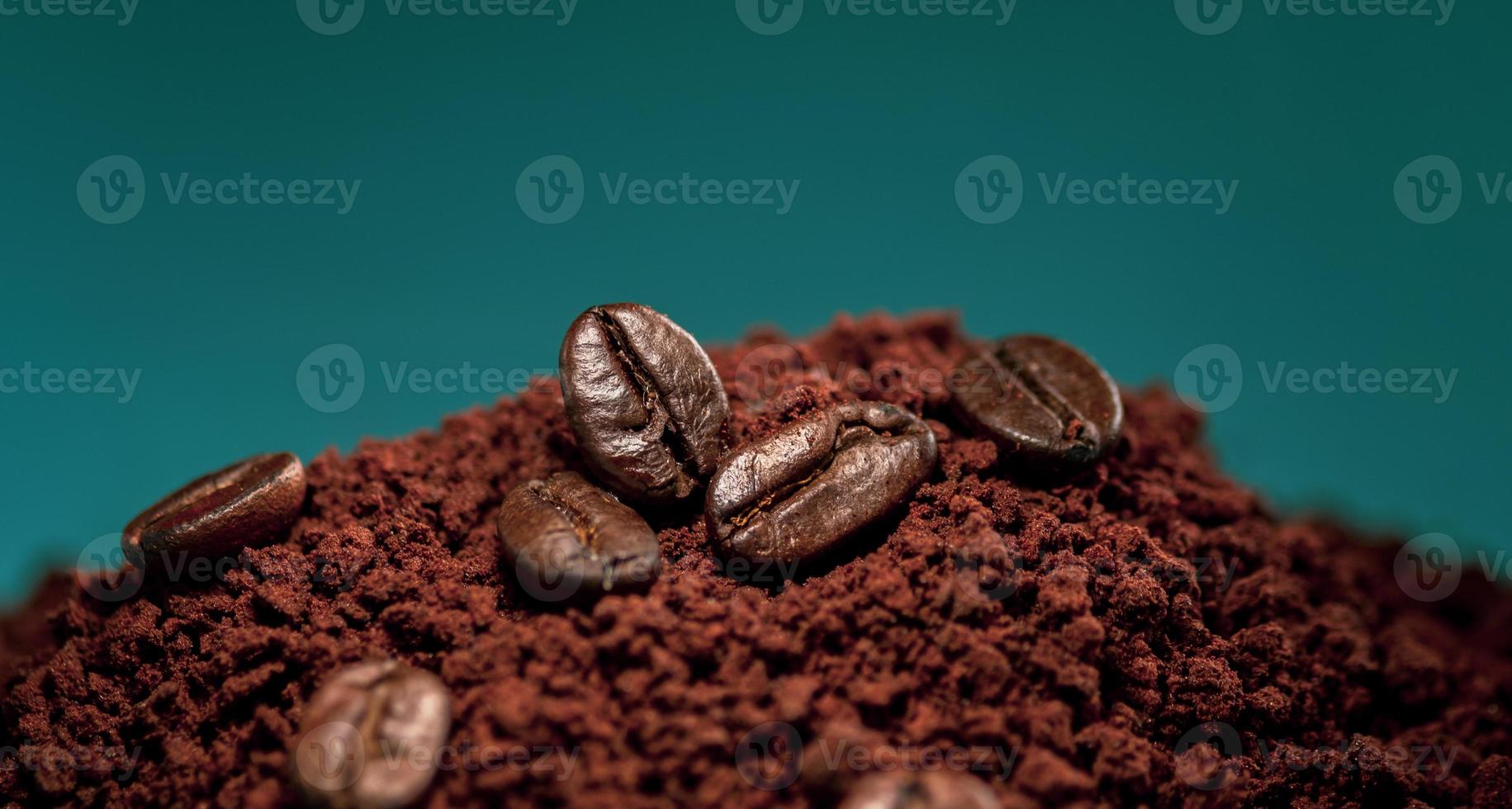 Coffee beans on a pile of ground coffee powder photo
