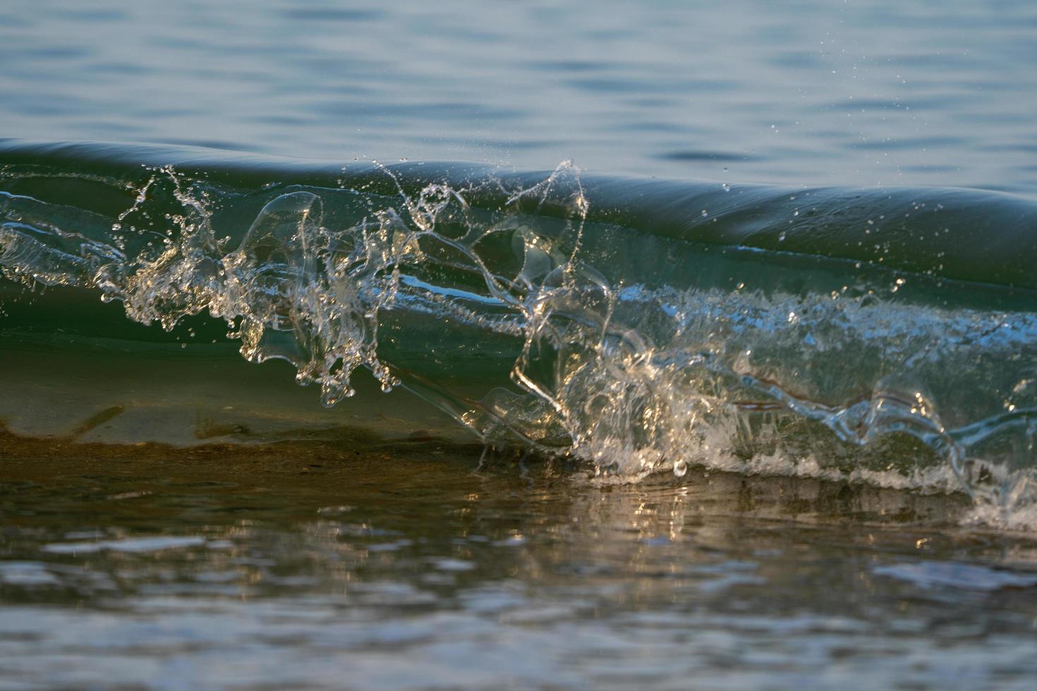 Waves about to break on beach at low tide photo