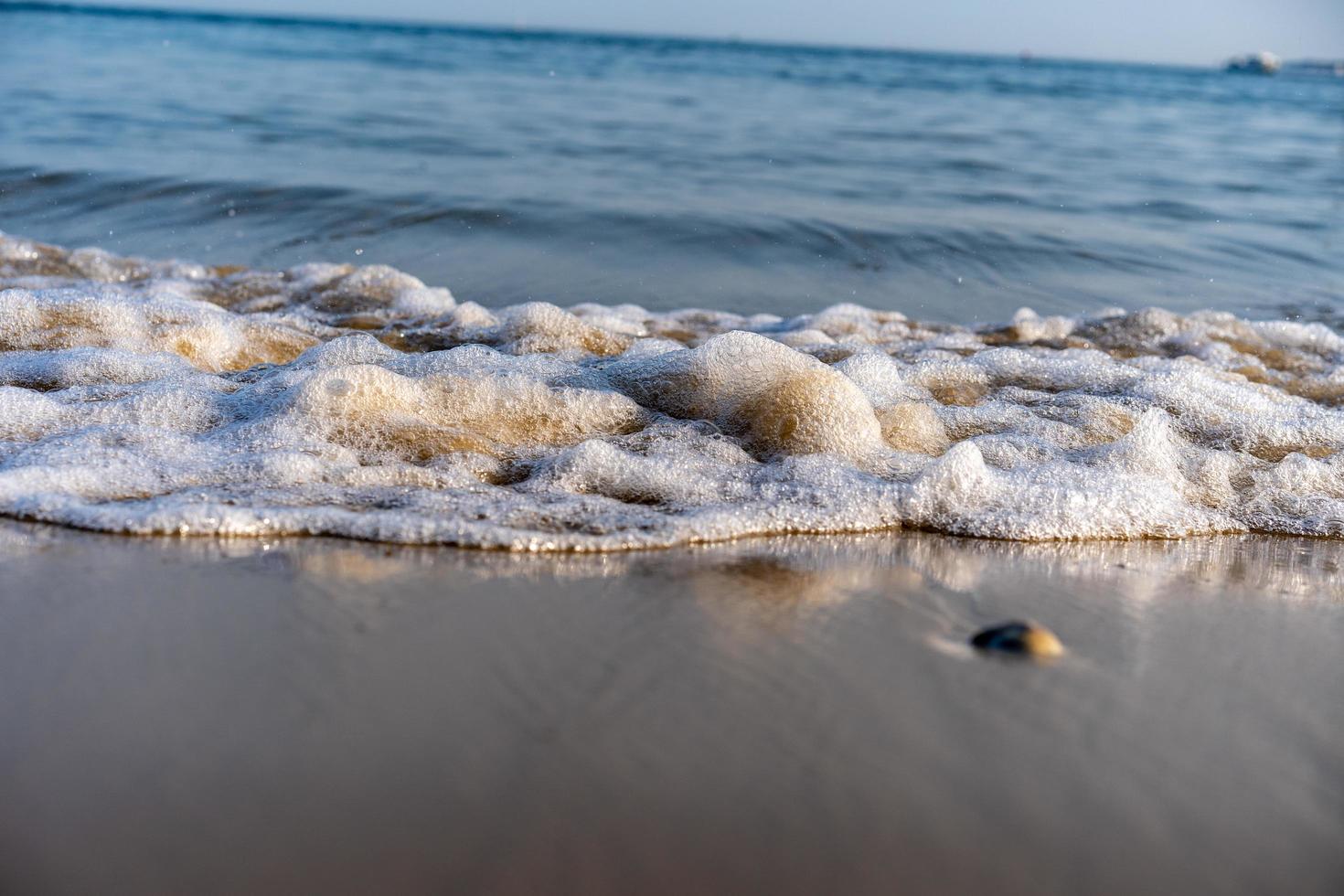olas burbujeando en la playa foto