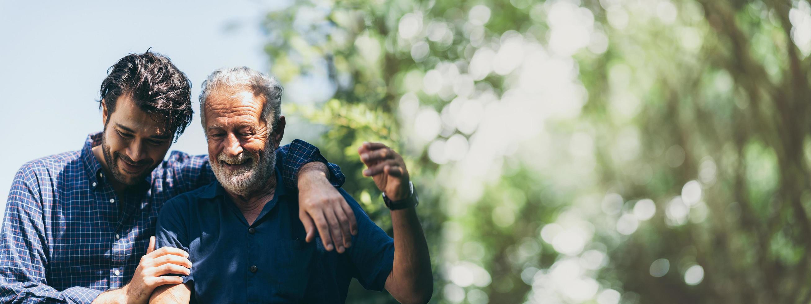 padre mayor con un hijo adulto en el fondo de la pancarta del concepto familiar con espacio para copiar, un anciano mayor es feliz y disfruta con un hijo hipster juntos caminando al aire libre en la naturaleza foto