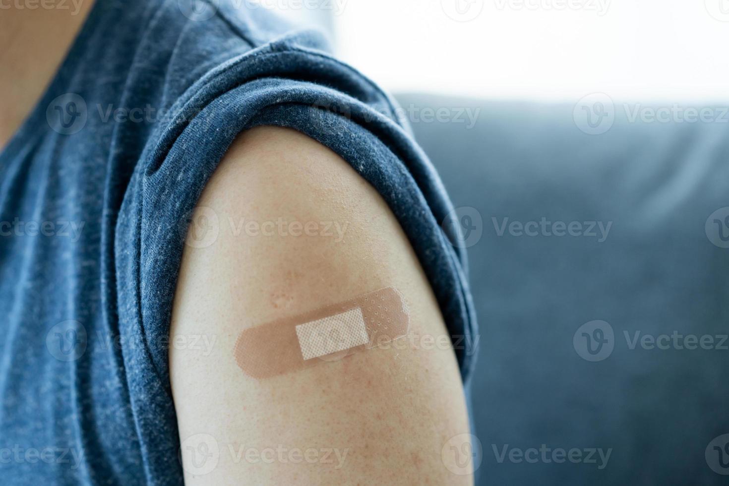 Man showing a vaccination point at his left arm. photo