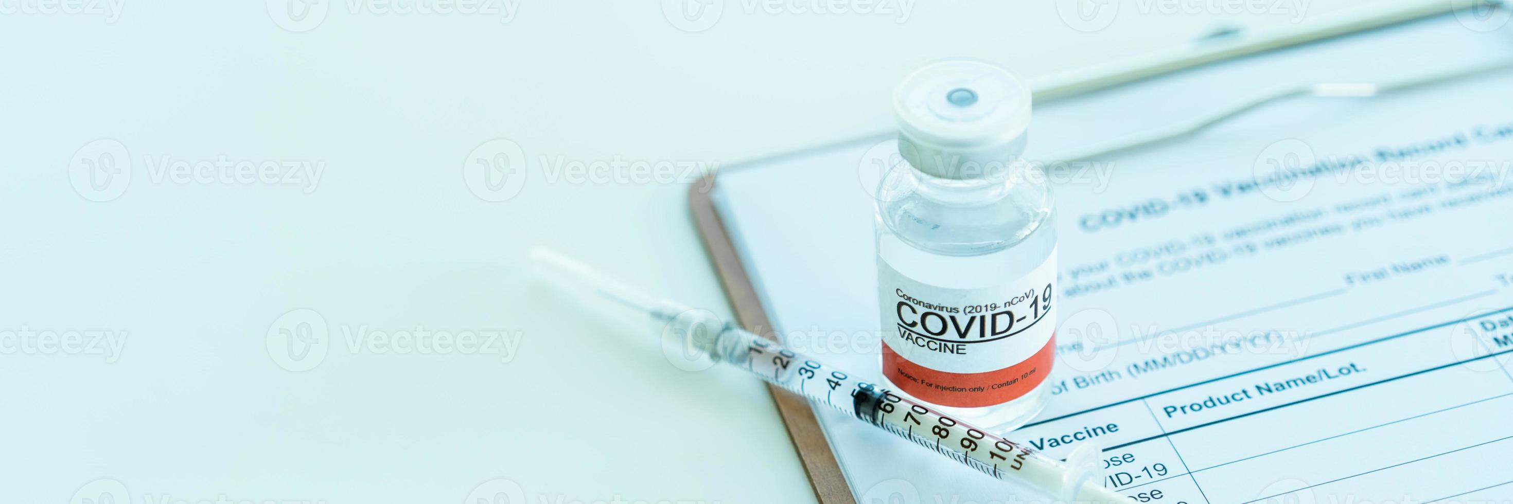 Coronavirus 2019-nCoV or COVID-19 vaccine and medical needle on the COVID-19 vaccination record. photo