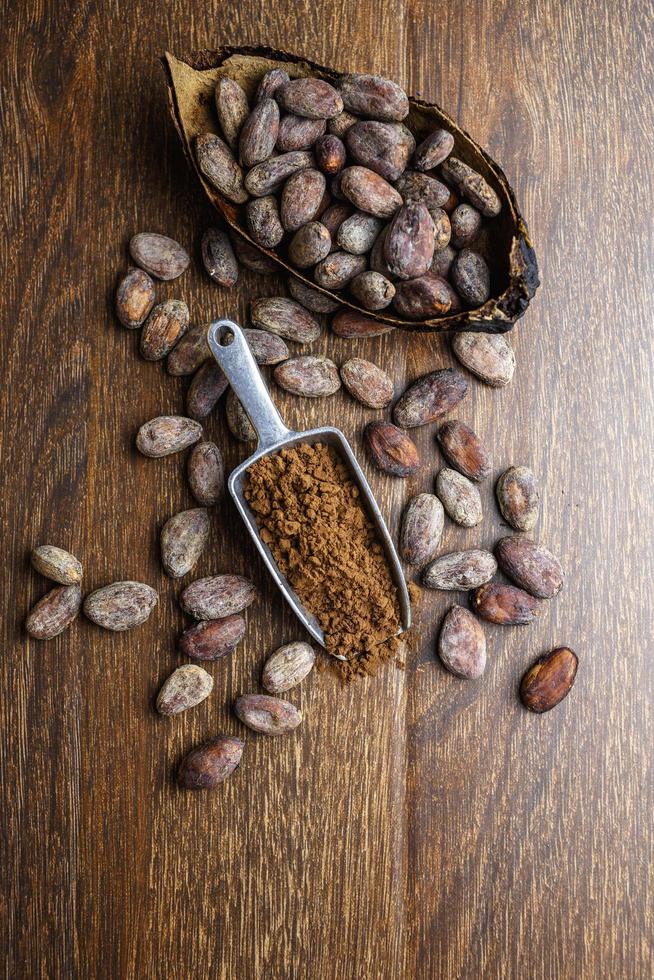 Cocoa powder and cocoa bean on wooden table photo