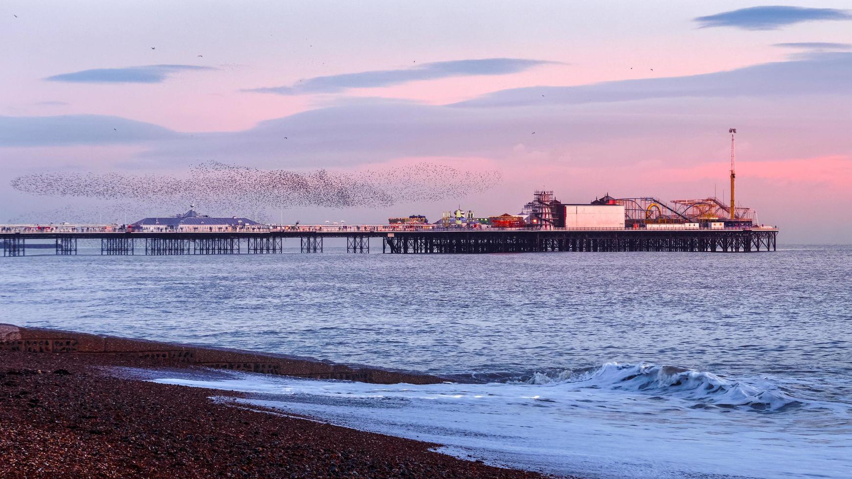 BRIGHTON, EAST SUSSEX, UK. Starlings over the Pier in Brighton East Sussex on January 26, 2018. Unidentified people photo