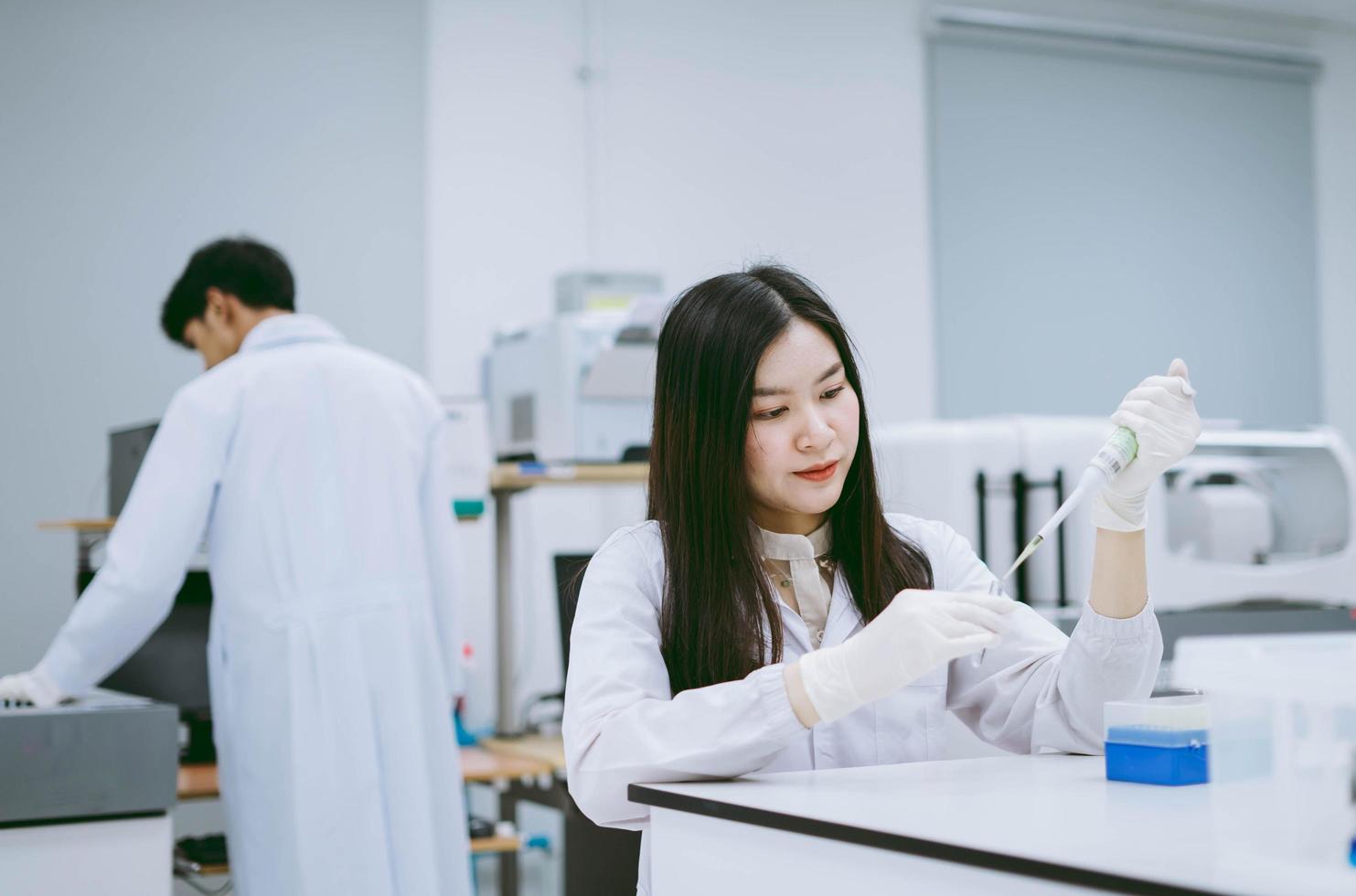 joven científica médica que trabaja en laboratorio médico, joven científica que usa pipeta automática para transferir muestras foto