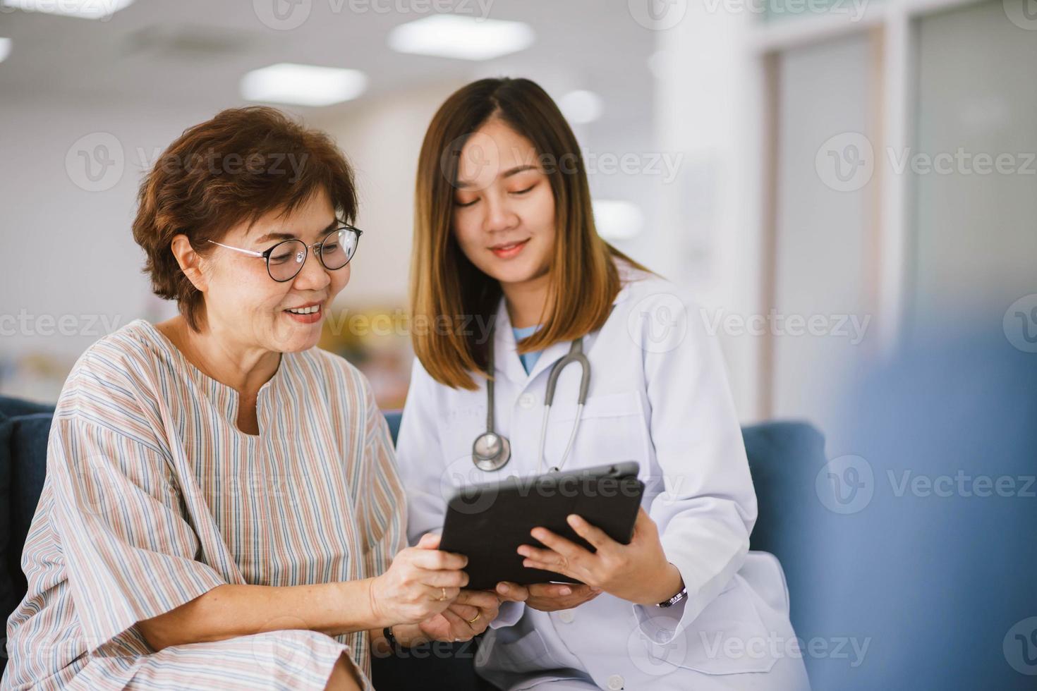 médico joven que consulta a un paciente mayor en la clínica de atención médica foto