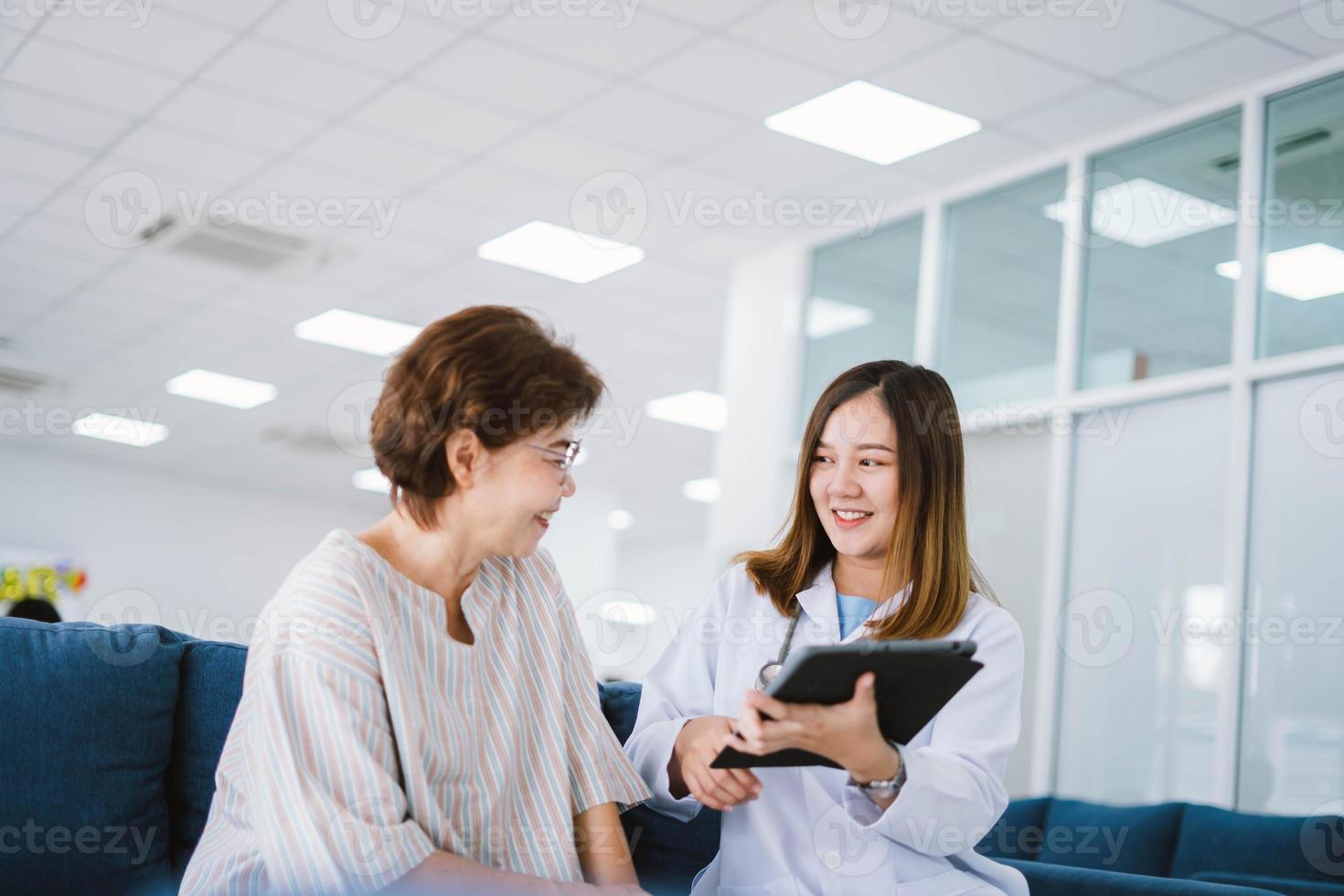 Young doctor consulting senior patient at health care clinic photo