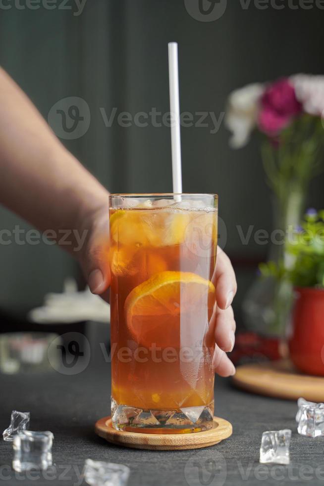 Glass of espresso with lemon juice and fresh sliced lemon on wooden table and copy space, Summer Cocktail, Cold brew coffee or black tea. photo