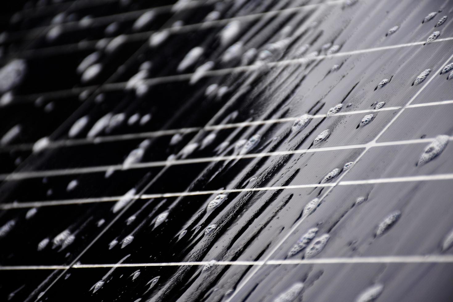 Closeup photovoltaic panel which had waterdrops and sponges on the surface, soft and selective focus, concept for using natural power in daily life around the world. photo