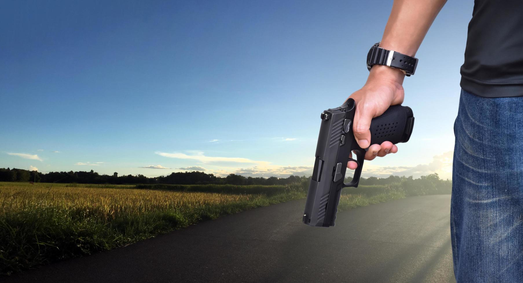 Pistola automática de 9 mm sujeta en la mano derecha del tirador, concepto de seguridad, robo, gángster, guardaespaldas en todo el mundo. enfoque selectivo en pistola. foto