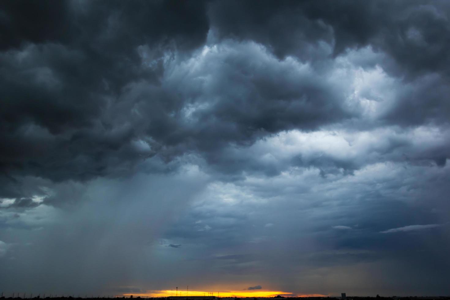 The dark sky had clouds gathered to the left and a strong storm before it rained. photo