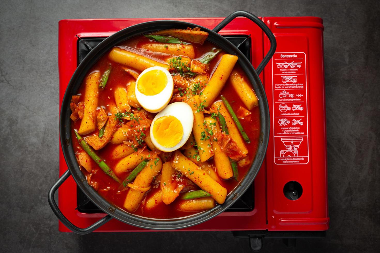 Cheesy Tokbokki korean traditional food on black board background. Lunch dish. photo