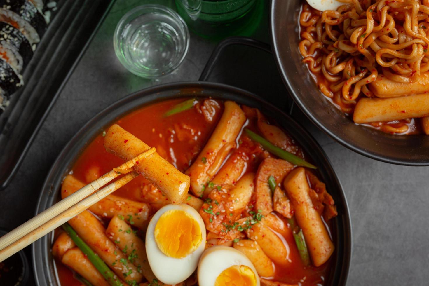 Cheesy Tokbokki korean traditional food on black board background. Lunch dish. photo