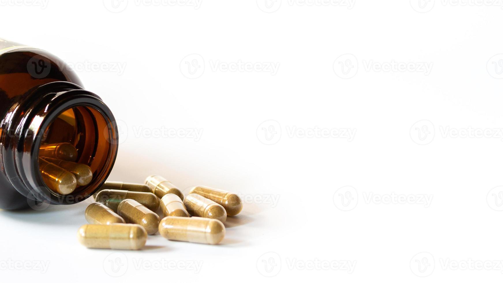 Herbal medicine capsules and glass bottles on a white background photo